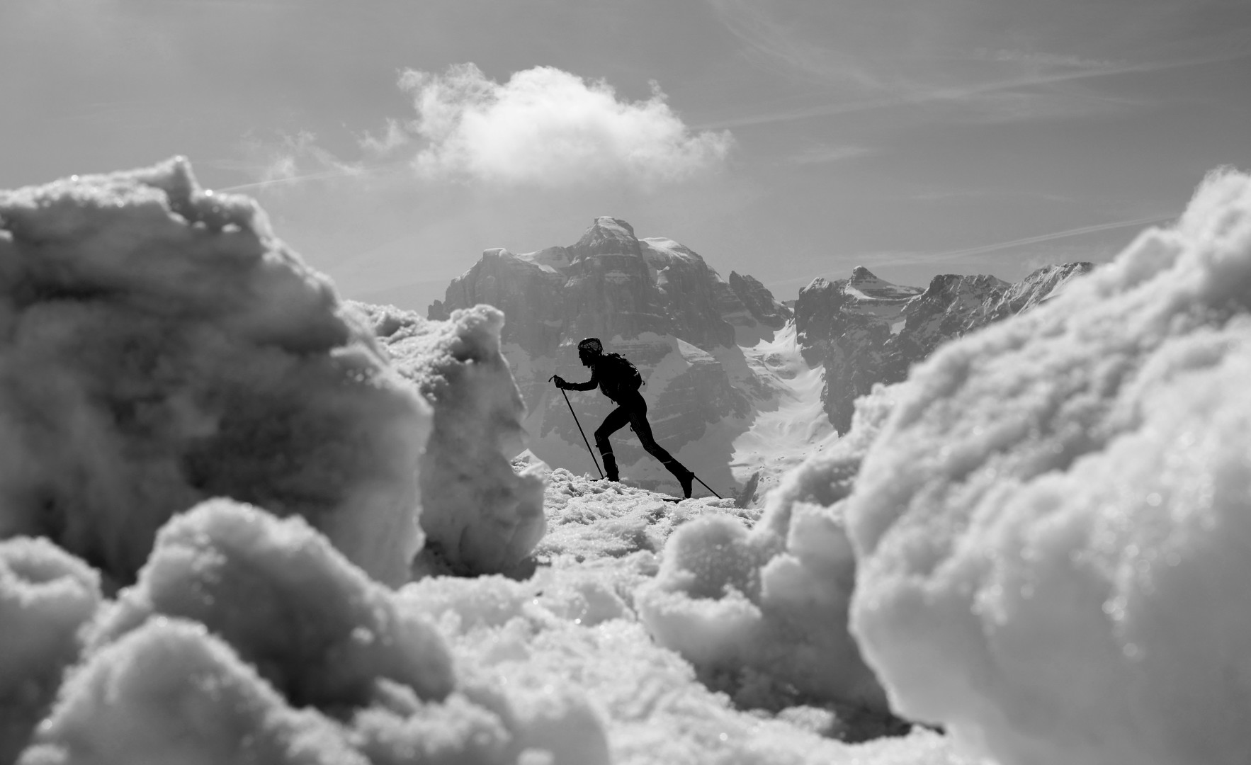 Black & White photograph of an athlete snowshoeing up a snowy mountain.