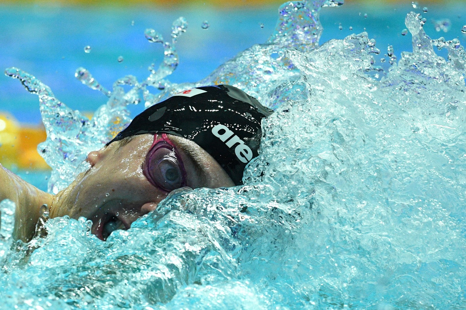Swimmers head appearing through the splash of water.